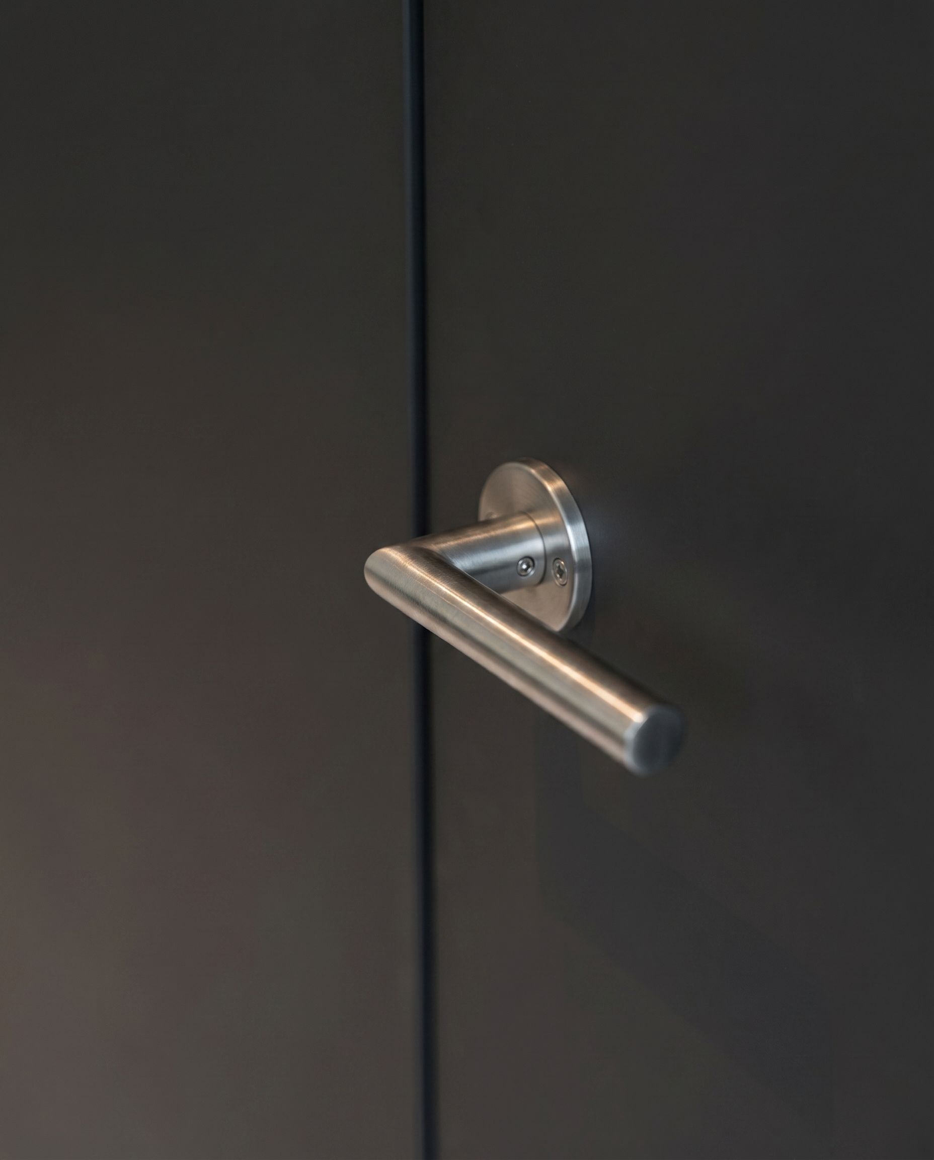 Detailaufnahme der Arbeitsplatte aus weißem Quarzkomposit mit integrierter Spüle und Wasserfallkante.