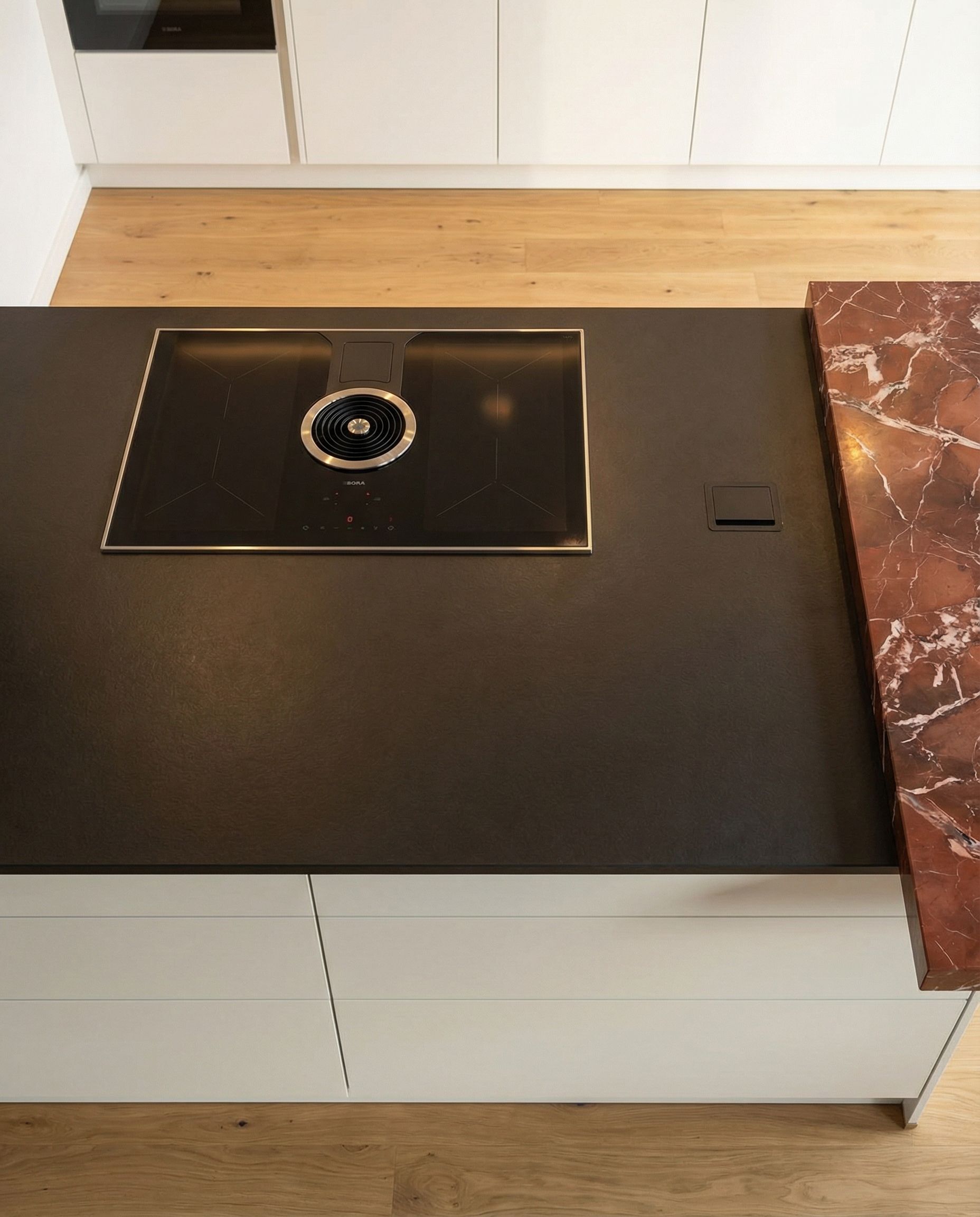 BORA Pure Induktionskochfeld mit Kochfeldabzug in schwarzer Keramikarbeitsplatte.