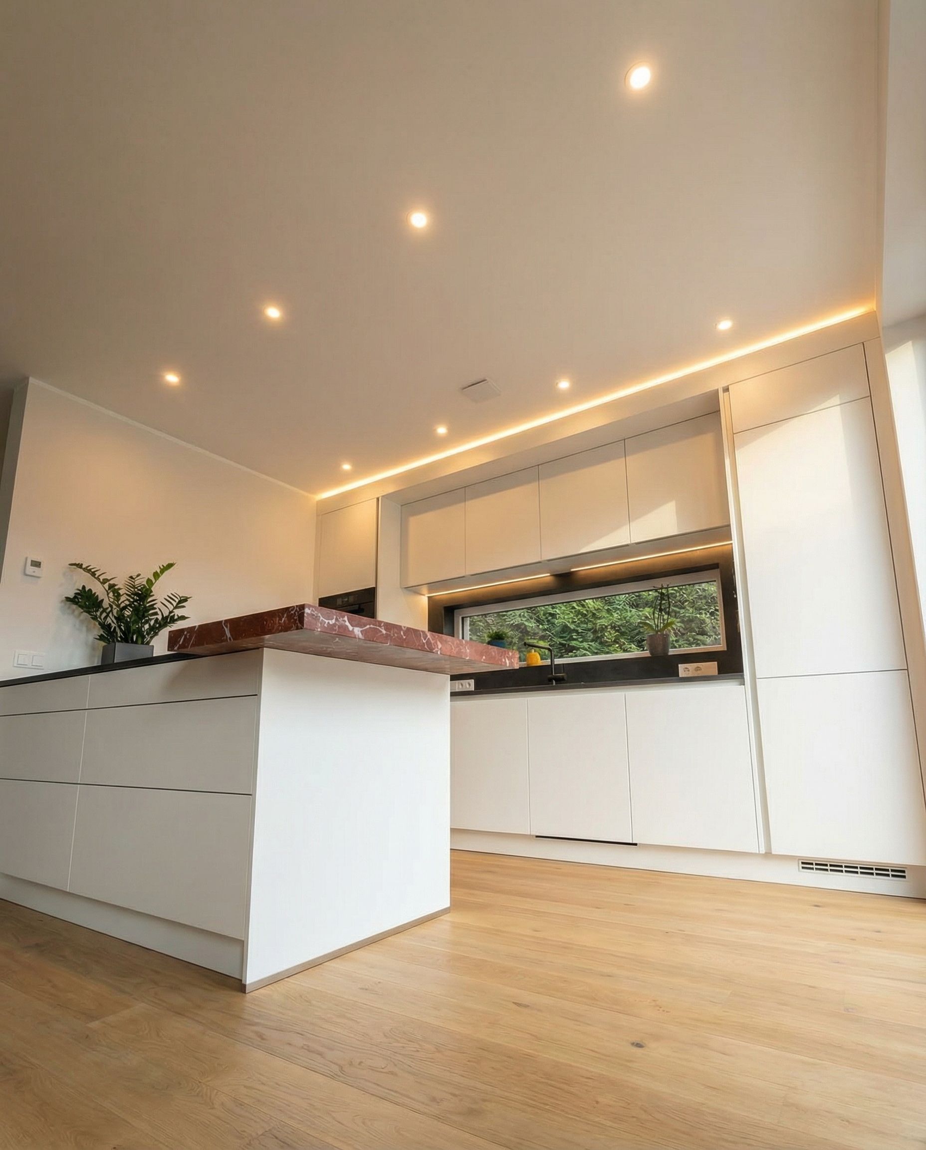 Hohe weiße Hochschränke mit integrierten Siemens-Geräten und Deckenbeleuchtung.